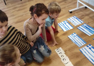 Dzieci układają kolejne litery aby ułożyć napis Ateny.